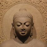 gray concrete buddha statue in white floral textile
